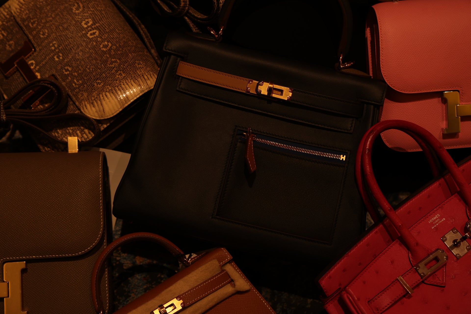 Curated collection of Hermès luxury bags in black, brown, and red leather, photographed for The Orange Box, a luxury bag shop in BGC, Philippines.